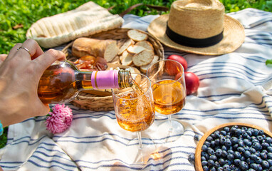 Wine in hands of woman at picnic. Selective focus.