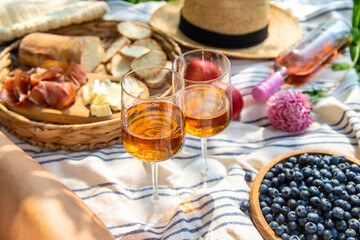 Wine in hands of woman at picnic. Selective focus.