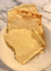 Pane carasau, traditional sardinian flatbread, served on a white plate
