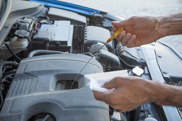 Fototapeta premium Man checking level of oil in car engine.