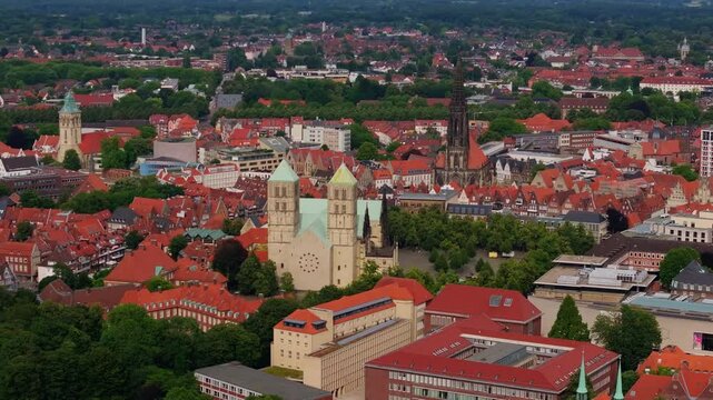 Camera pans over the red rooftops and St. Paulus Dom of Munster, germany. The iconic Cathedral is prominently featured in the center