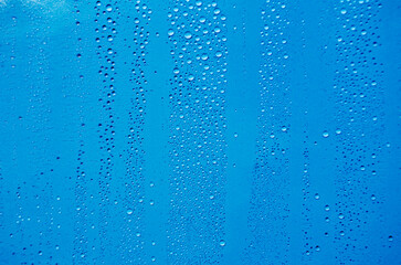 Close up of rain droplets on blue cover background. Suitable for wallpaper background.