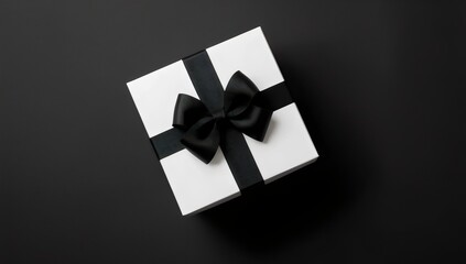 Gift box with black ribbon on black background. Black Friday concept.