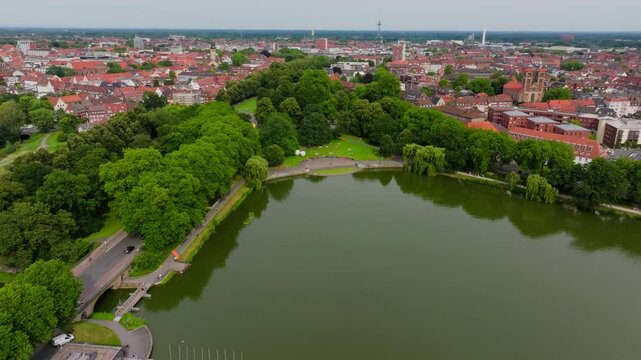 Aerial view of the city of Munster, germany. The camera is panning over the Aasee lake and its marina, surrounded by lush green trees and buildings