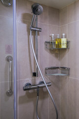 Elegant modern design bathroom with sink, shower, towels and mirror and nature stone tiles in cabin...