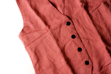 Details of terracotta sleeveless pleated vest with black button in white background