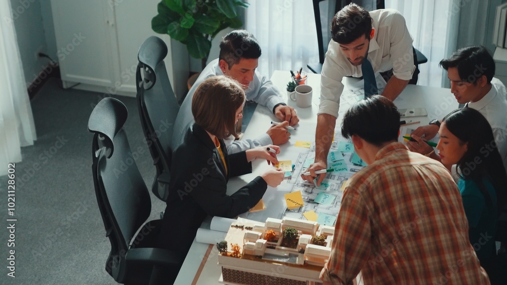 Poster group of diverse team planning strategy while sitting at table with project plan. top aerial view of