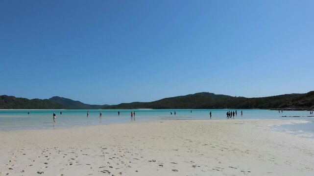 Long-shot of people walking on the Hill Inlet beach in the Whitsundays island, Queensland, Australia.