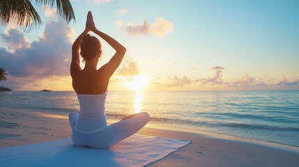 Woman practicing yoga on the beach at sunrise with a serene ocean view