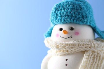 Cute decorative snowman against light blue background, closeup. Space for text
