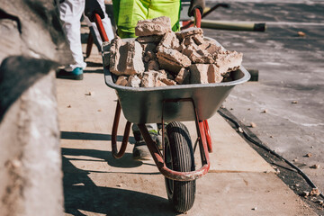 Bauarbeiter kippt Steine in Schubkarre