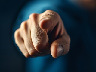 Close-up of a hand pointing directly at the camera, symbolizing choice, decision, and direction in a focused, dramatic manner.