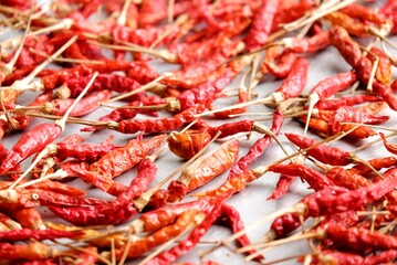 In selective focus a pile of red chilli on a tray and dry in a sun,outdoor space 