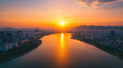 Naklejka premium A breathtaking scene of a radiant golden sunset casting its glow across a river that splits a bustling city with towering skyscrapers silhouetted against the skyline.