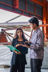 Female manager or inspector is checking or examining the quality control of metal sheet industry or factory with a professional male engineer employee, production quality control in metal warehouse.