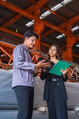 Female manager or inspector is checking or examining the quality control of metal sheet industry or factory with a professional male engineer employee, production quality control in metal warehouse.