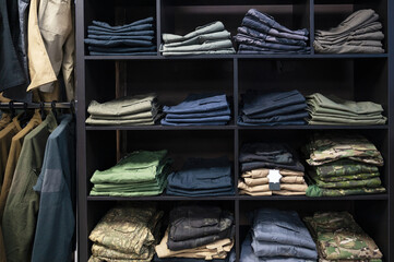 Folded Tactical Clothing and Military Uniforms on Shelves