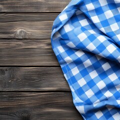 Obraz premium A blue and white checkered cloth draped over a wooden surface, creating a cozy and inviting atmosphere.