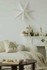 Festive fireplace setting. Elegant Christmas decor around the fireplace, with a white star,...