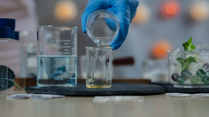 Scientist Pouring Liquid into Beaker in Cosmetic Laboratory with Decorative Elements. This image captures a scientific process in a cosmetic laboratory where a person wearing blue gloves.
