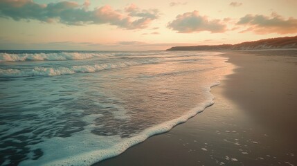 Fototapeta premium Tranquil sunset at a serene beach with gentle waves and a pastel sky.