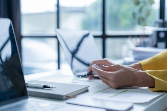 Business woman using smartwatch analyzing checking business data on financial documents, planning strategy analysis report, thinking and looking for new opportunities