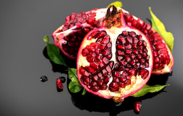 Pomegranate. Fresh juicy Pomegranates with leaves on dark gray background. Organic Bio fruits...