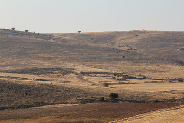 Ruins of a villa in the landscapes of dry desert-like spanish country with a road ending in the...