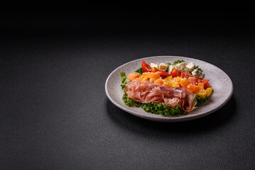Appetizing salad with prosciutto, pumpkin, cheese and tomatoes