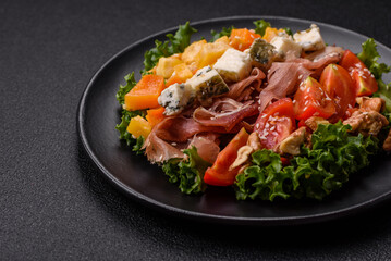 Appetizing salad with prosciutto, pumpkin, cheese and tomatoes