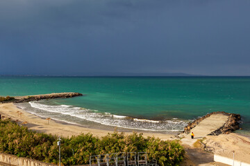 Elevated stormy Black Sea shoreline beach view with concrete piers at Pomorie, Province of Burgas, Bulgaria
