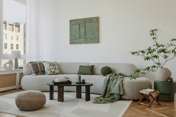 A modern, minimalist interior with a large sofa and natural accents. Soft greens bring harmony to...