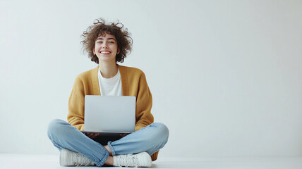 Smiling young woman sitting with laptop on white background
