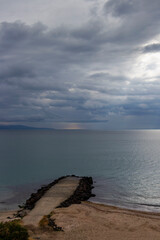 Stormy morning Black Sea shoreline beach view with a concrete pier at Pomorie, Province of Burgas, Bulgaria