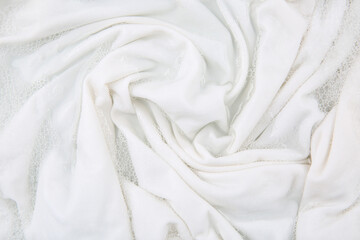 Washing laundry in water with foam, top view