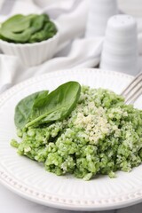 Tasty spinach risotto served on table, closeup