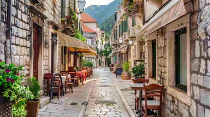 Narrow street in a European city with old buildings and charming outdoor cafes.