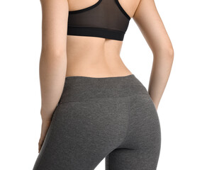 Woman wearing sports leggings and bra on white background, closeup