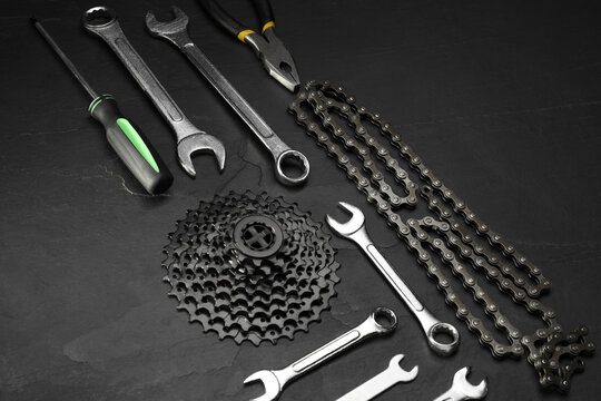 Parts of bicycle and tools on black table