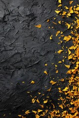 Obraz premium Yellow petal scatter on dark textured surface for abstract background