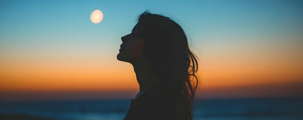 Fototapeta premium Silhouette of a Woman Gazing at the Moon During a Colorful Sunset