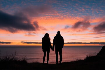 Silhouette of a Couple Holding Hands at Sunset Over the Ocean