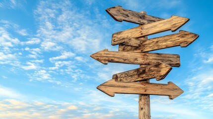 A weathered wooden signpost with multiple arrows pointing in different directions against a blue sky.
