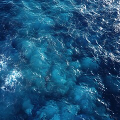 Obraz premium Aerial view of deep blue ocean water with sunlight reflections creating a mesmerizing pattern.