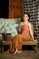 Fototapeta premium Young Indonesian women or fashion models wearing traditional Indonesian clothing or attire with batik motifs from Indonesian culture. Making or painting batik cloth. Making batik cloth.