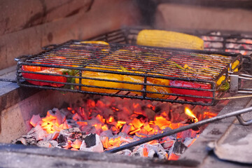 Peppers are cooked on hot coals in chargrill. Peppers broils in barbecue