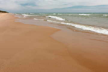 The Lake Michigan beach at Kohler-Andrae State Park, Sheboygan, Wisconsin is void of visitors on this early May spring morning.  Another month and beach combers will enjoy the beach.