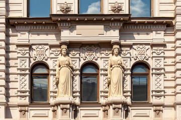 A fragment of the facade of an old mansion with columns in the form of female figures