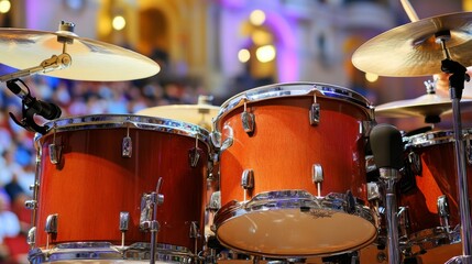 Obraz premium Orange Drum Set, a Symbol of Musical Energy and Rhythmic Precision on Stage Under Lights.