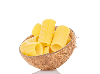 Raw durum wheat cannelloni pasta in coconut shell, macro, isolated on white background.